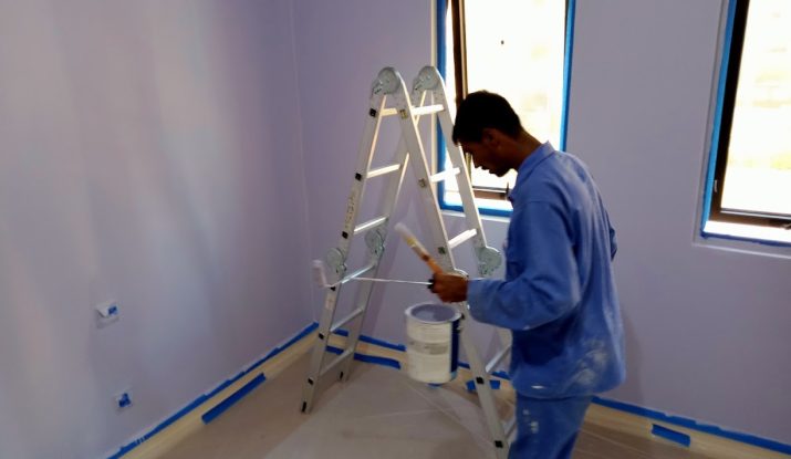 Painter applying paint to an interior wall in Abu Dhabi