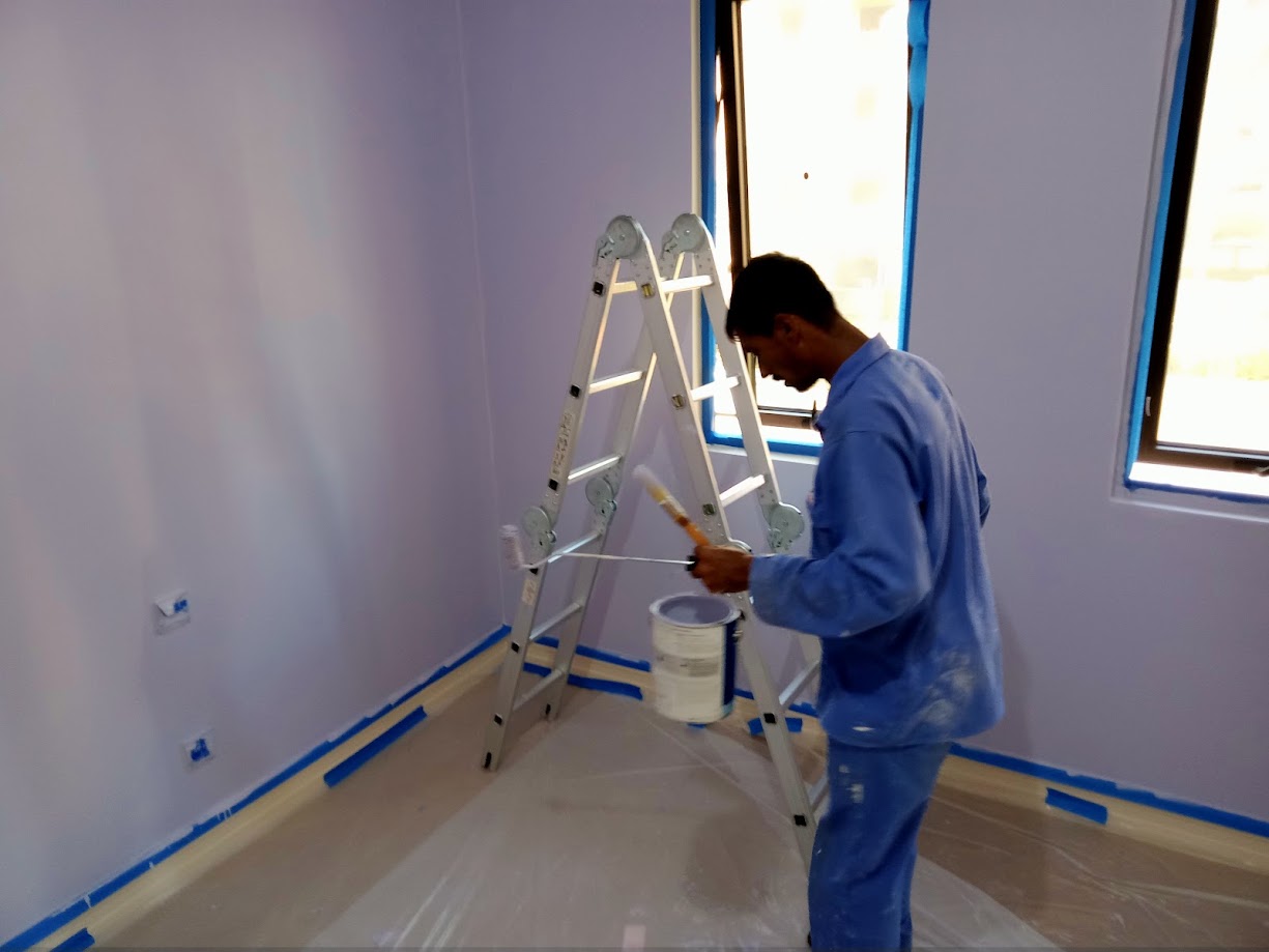 Painter applying paint to an interior wall in Abu Dhabi